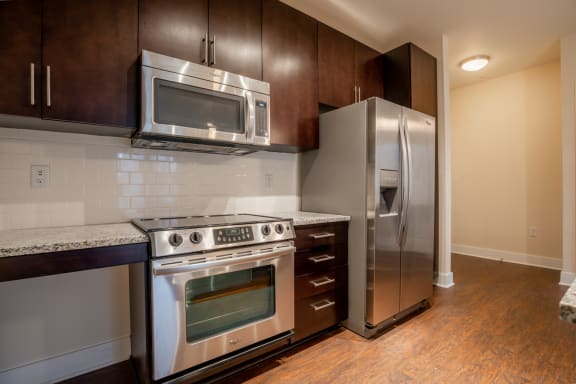 Modern kitchen with wooden cabinets at West 39th Street Apartments, Kansas City, MO, 64111