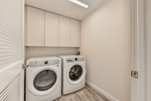 Washer/Dryer Room with Hardwood Inspired Floor and White Cabinets at Morgan Ranch Apartments, Morgan Hill