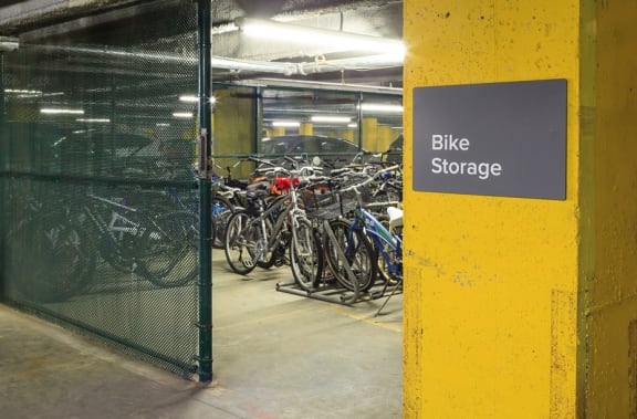 Bike storage area with bikes parked behind a fence at 10 West Apartments, New York 11561
