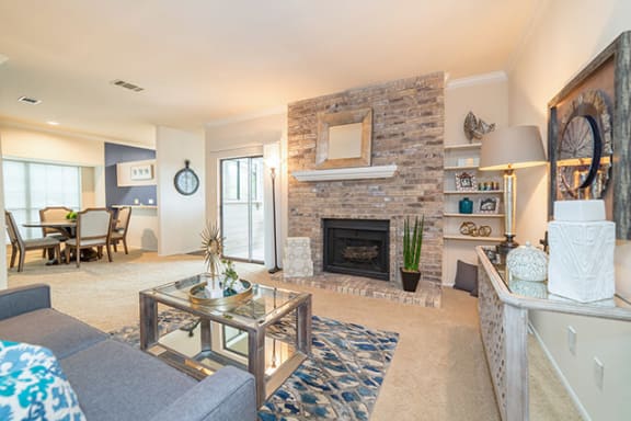 a living room with a fireplace and a table at High Oaks, Austin