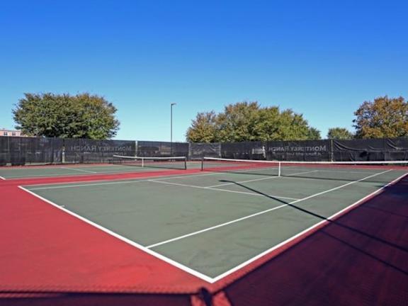 a tennis court with trees in the background at Monterey Ranch, Austin, Texas