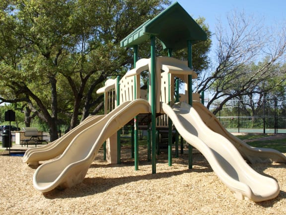 a playground with slides and a climbing tower