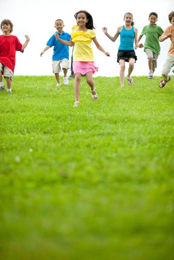 kids running across grass field