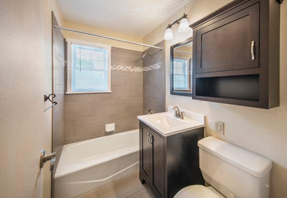 A bathroom with a white tub, sink, and toilet at Rivercrest Apartments, Piscataway