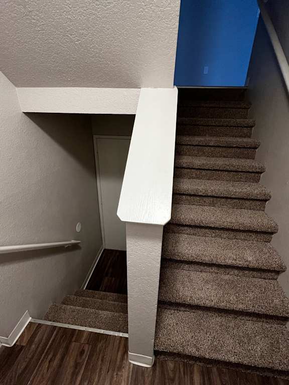 Staircase down to garage and upstairs to living areas in Madrona unit