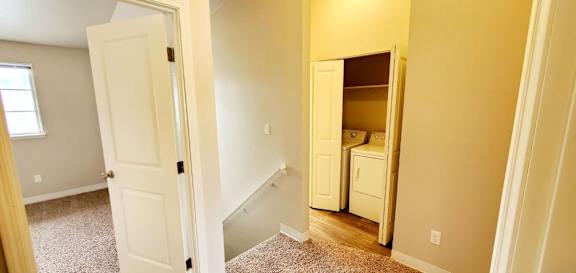 Landing at top of stairs in Fountainside unit with Laundry closet shown