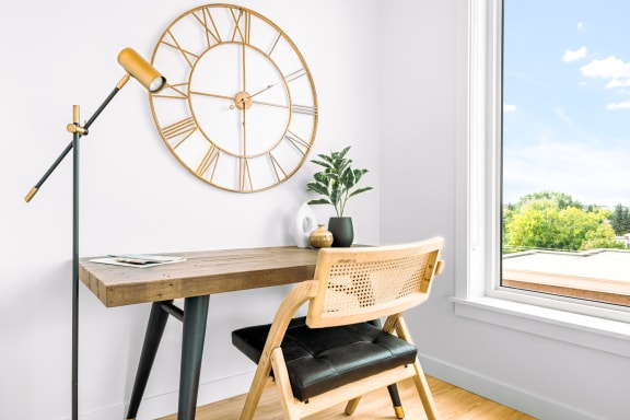 a desk with a chair and a clock on the wall