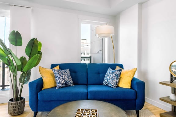 a living room with a blue couch and a round coffee table