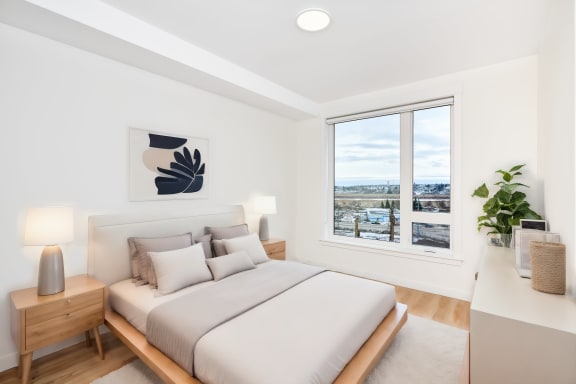a bedroom with a bed and a large window