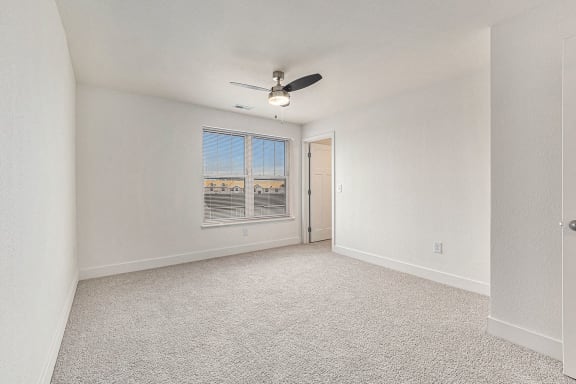 Bedroom with plush carpeting and large window at Eagle Ridge Apartment Homes, Traverse City, 49685