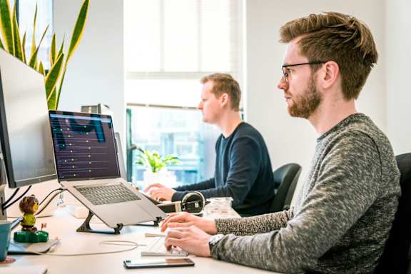 Two men working on computers at a desk
