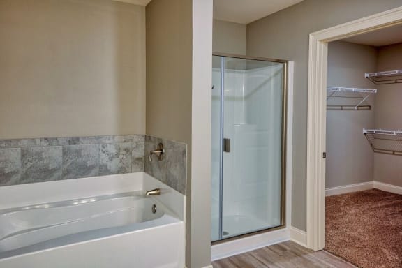 A bathroom with a white tub and a glass shower door at Mode at Melbourne, LLC Apartments, Florida