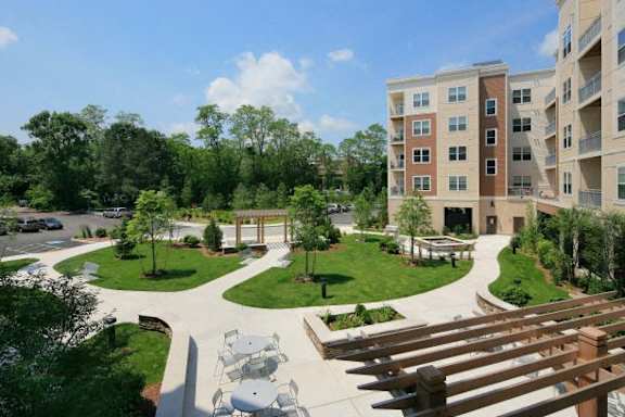 A view of a courtyard with a wooden structure in the foreground and apartment buildings in the background.