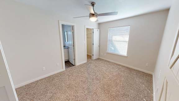 Large carpeted bedroom with walk in closet and laundry connections