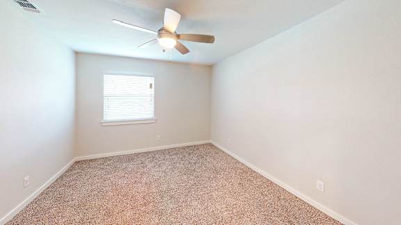 Bedroom with carpeted floors and ceiling fan.