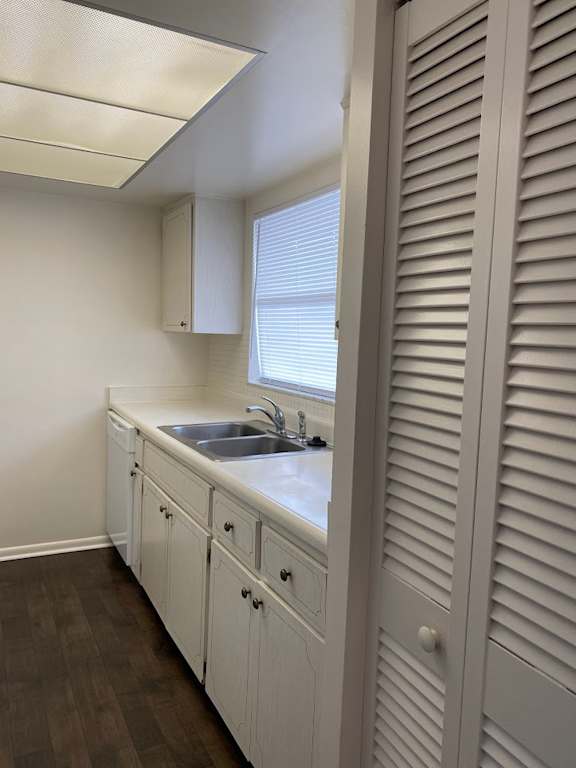 A white kitchen with a sink and wooden cabinets at Imperial Gardens Apartments, Clearwater 33764