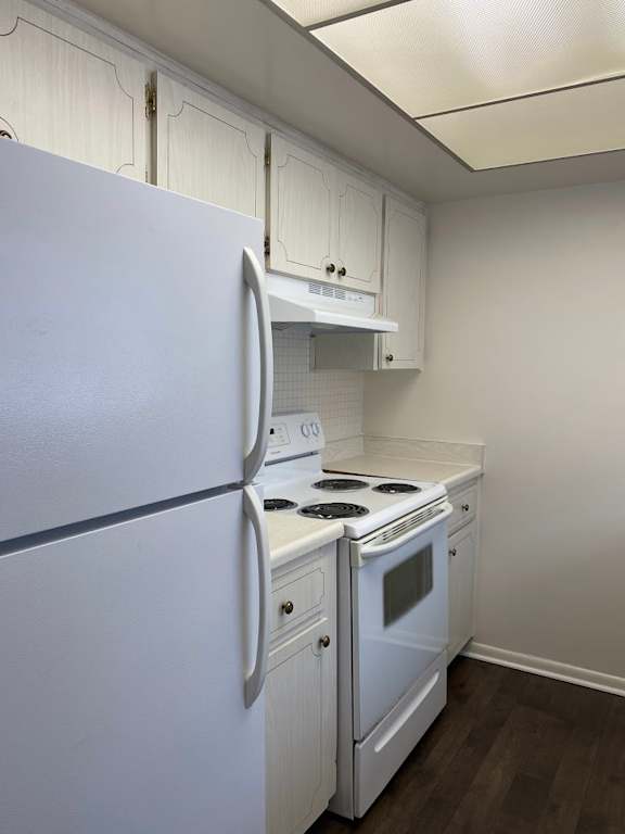 A white refrigerator and stove in a kitchen. at Imperial Gardens Apartments, Clearwater 33764