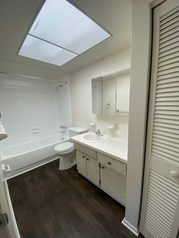 A white bathroom with a skylight. at Imperial Gardens Apartments, Clearwater