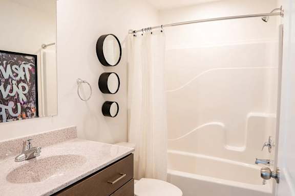white bathroom with a shower curtain and a sink.