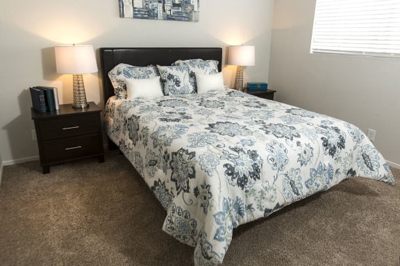 Bedroom in Fifteen 50 apartments in Las Vegas near UNLV with queen bed and plush carpeting.