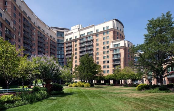 The Metropolitan in Bethesda, MD building exterior with beautifully landscaped open green areas with grass and trees.