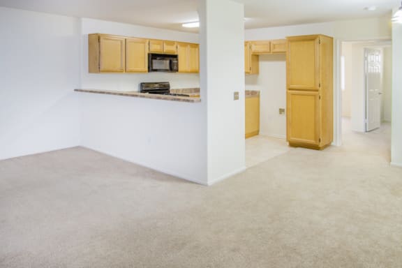 living room with plush carpeting leading to a kitchen at Toscana Apartments, Van Nuys California