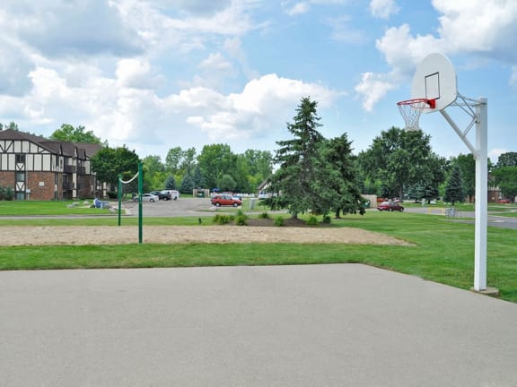 Outdoor basketball and sand volleyball courts at Charter Oaks Apartments in Davison, MI