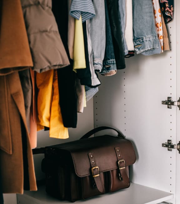a wardrobe with a briefcase and jackets hanging on the wall