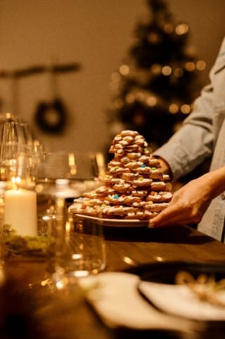 a person holding a plate of cookies on a table