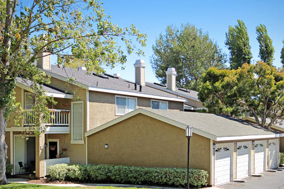 a tan house with a garage and trees at Harbor Pointe, California, 92629