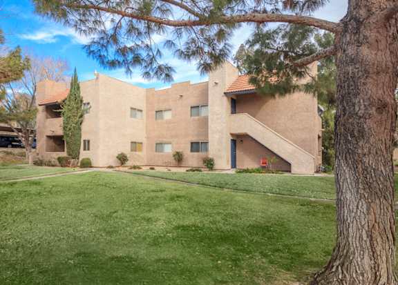 the exterior of a building with a green lawn and trees at Desert Bay Apartments, Laughlin, Nevada, 89029