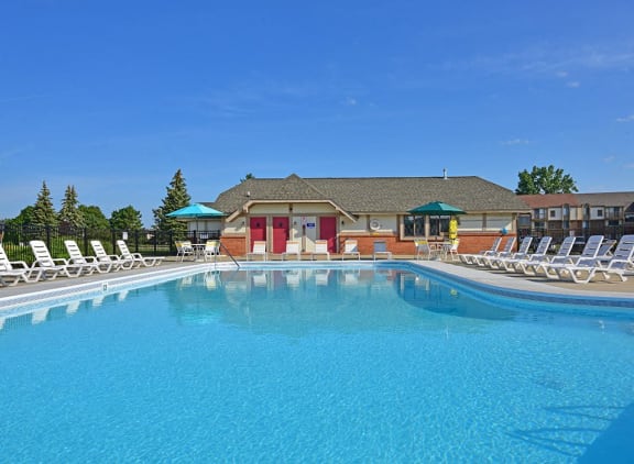 Outdoor pool and wrap-around sundeck area at Perry Place Apartments in Grand Blanc, Michigan