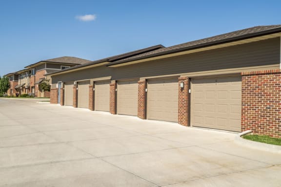 A row of garage doors in front of a brick building.