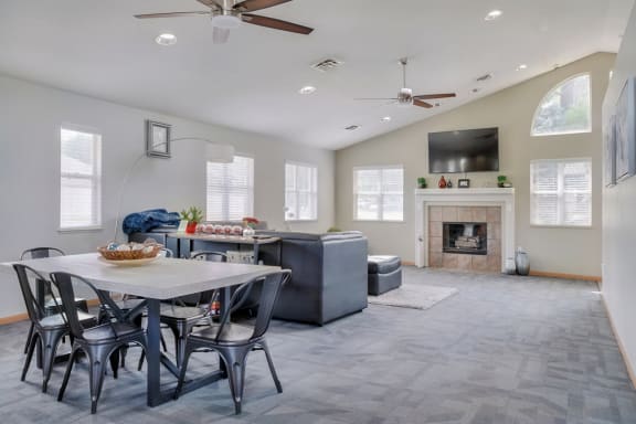 Common area with lounge area and fireplace with TV mounted above it in the clubhouse at Skyline View apartments