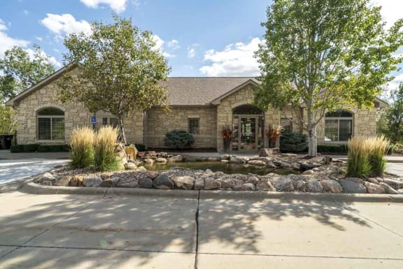 A house with a front yard and a pond.