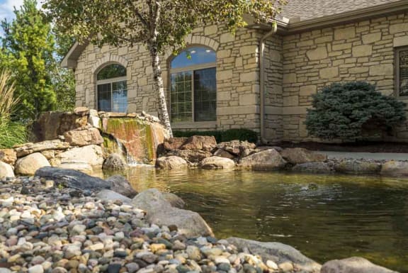A house with a pond in front of it.