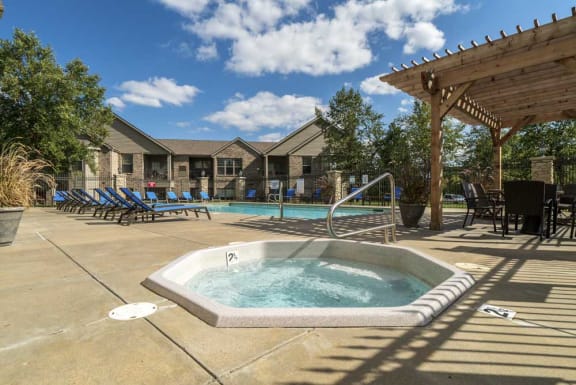 A hot tub sits in the middle of a patio area.