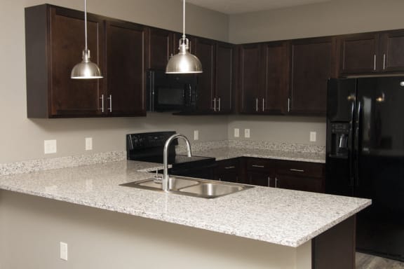 Kitchen with lots of granite counter space and matching all black appliances Comfortable couch seating in the clubhouse at North Pointe Villas in north Lincoln, Nebraska