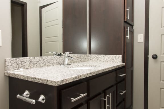 Bathroom with granite counter tops and lots of cabinet space in dark finish at North Pointe Villas in north Lincoln, Nebraska