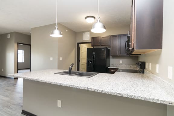 Kitchen with lots of granite counter space and matching all black appliances Comfortable couch seating in the clubhouse at North Pointe Villas in north Lincoln, Nebraska