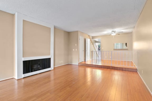 an empty living room with hardwood floors and a fireplace