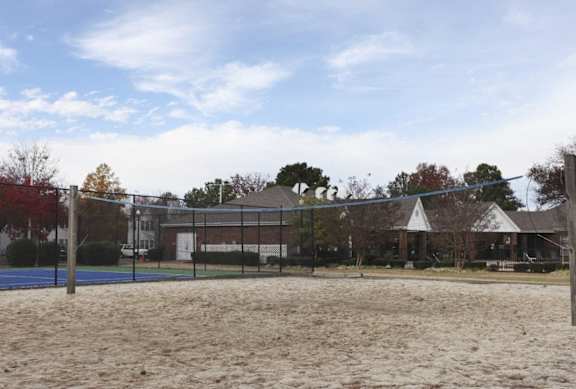 A sandy volleyball court with a net and a building in the background at The Trails at Mt. Moriah, Memphis, 38115