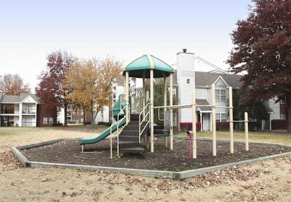 A playground with a green slide and a wooden structure at The Trails at Mt. Moriah, Tennessee 38115