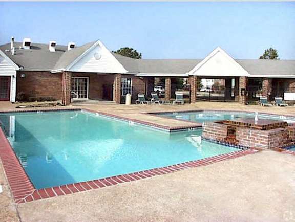 A pool with a red brick border and a building in the background at The Trails at Mt. Moriah, Memphis, TN 38115