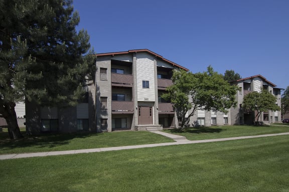 Three story apartment building exterior at Woodland Villa Apartments in Westland