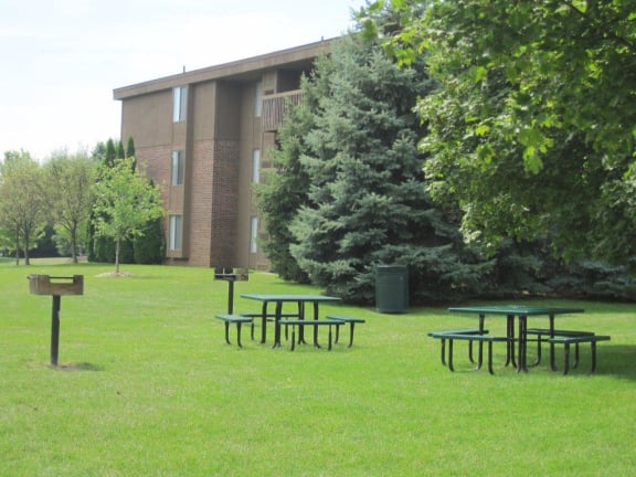 Outdoor Picnic and BBQ Areas with beautiful green landscaping at Dover Hills Apartments at 4520 Dover Hills Drive, Michigan