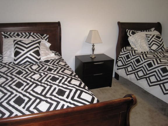 Bedroom with twin beds in Short-Term Furnished Unit available at Dover Hills Apartments in Kalamazoo, Michigan