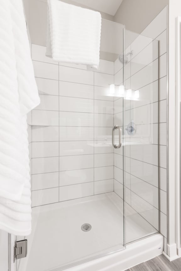 Walk in shower surrounded by grey rectangle tiles