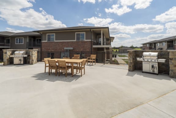 A patio with a table and chairs is surrounded by houses.