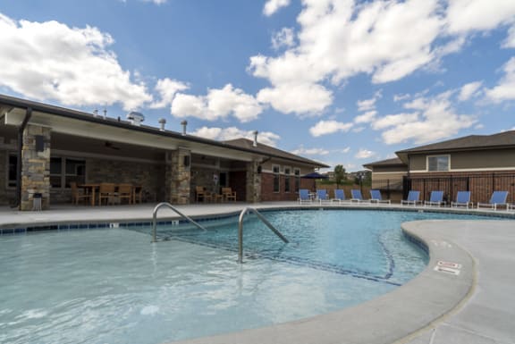 A swimming pool with a slide and a building in the background.